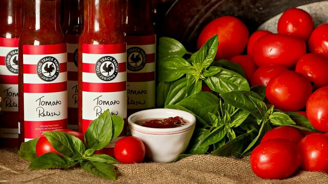 Homemade relishes and sauces from fresh local ingredients Jars of homemade relishes with fresh tomatoes and basil