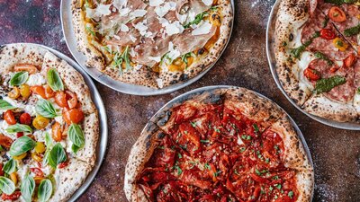 Four types of pizza laid out on a table