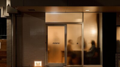 A buzzing restaurant behind frosted glass, subtly hiding what is inside.