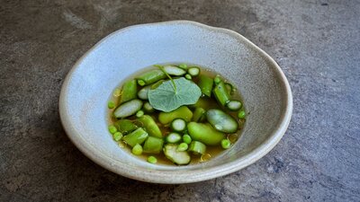 Broad beans, peas + nasturtium in a clear broth.