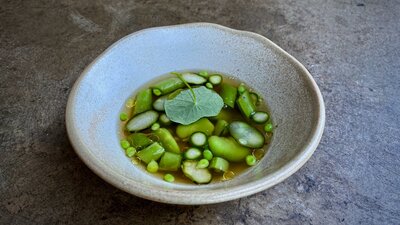 Broad beans, peas + nasturtium in a clear broth.