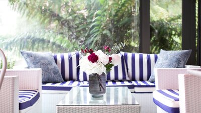 Fresh blue and white furniture by a window overlooking the rainforest garden