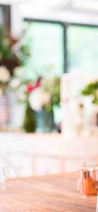 Beautiful white jug filled with fresh flowers on a wooden table