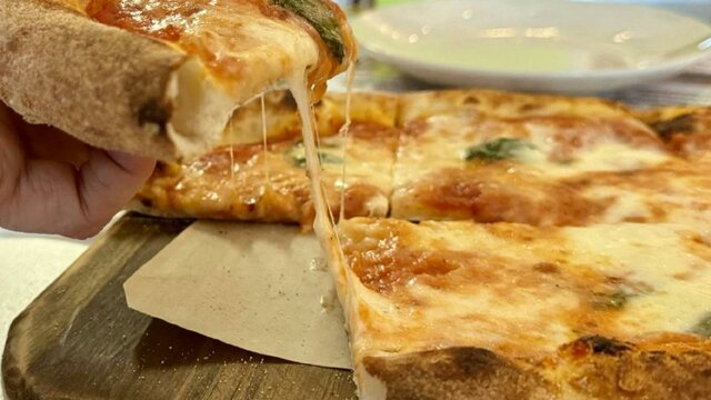 Slice of pizza with melted cheese