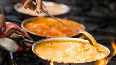 Chef cooking curries on a gas stove