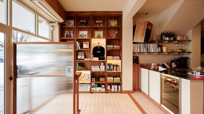 this photo shows a retail display of coffee and books, a front counter of a cafe and some vinyl