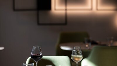 A table of two set for dinner with meals and wine glasses.