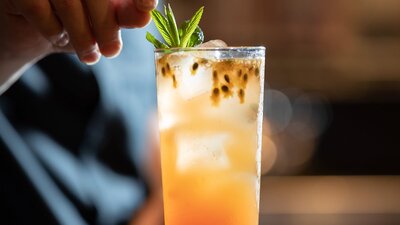 A bartender puts the finishing touches on an orange cocktail