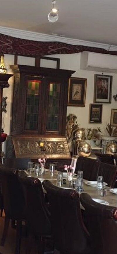 Empty restaurant setting with cutlery and crockery laid out on table