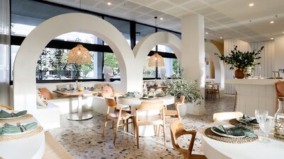 Interior of restaurant with white and brown tables and chairs