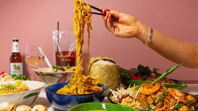 Hand using chopsticks to pick up noodles