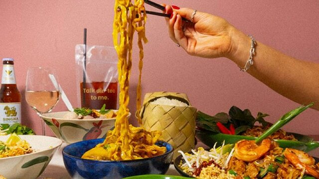 Hand using chopsticks to pick up noodles