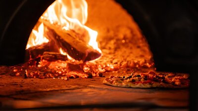 Pizza cooking in woodfired oven