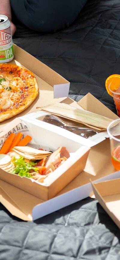 Various food and drinks on a picnic rug