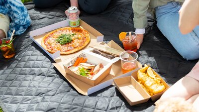 Various food and drinks on a picnic rug