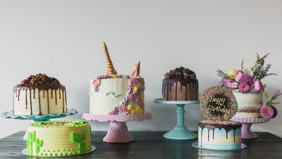 Line of decorated cakes of all colours and shapes.