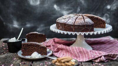 Chipotle Chocolate Cake on a stand and a few slices on plates.