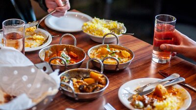 Dining table with a variety of food dishes in front of diners