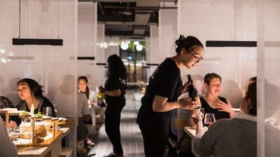 Service staff talking to patrons sitting at tables