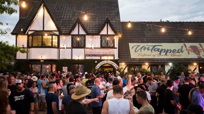 Crowd of people standing outside and old English style pub