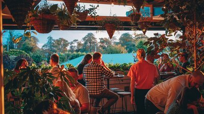 Group of people sitting watching sunset from upstairs bar