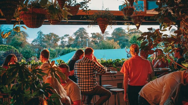 Group of people sitting watching sunset from upstairs bar