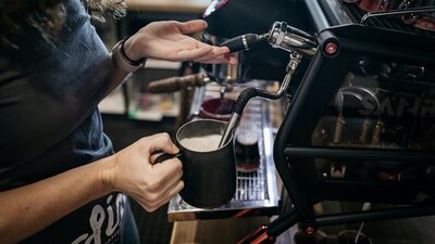 Trader & Co Barista serving award-winning, in-house roasted specialty Six8 Coffee.