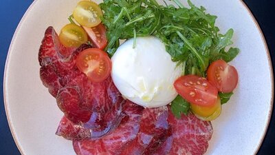 Dish with meat, cheese, tomato and rocket