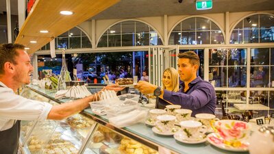 Couple couple being served cake over the counter