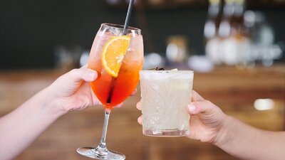 Close up of two hands holding drinks