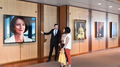 A person showing a portrait to a family of three