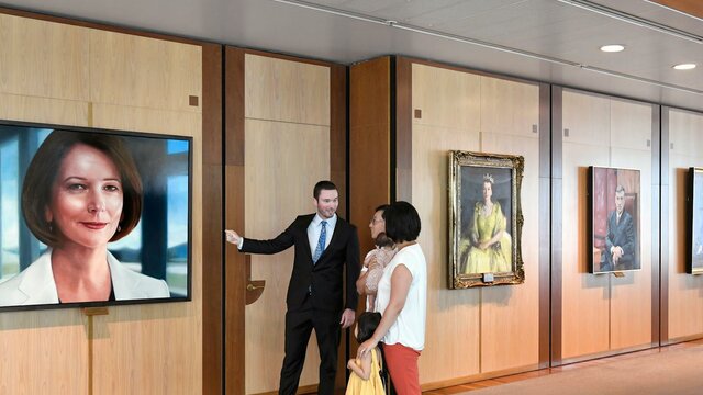 A person showing a portrait to a family of three