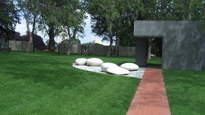 Paved path with mown lawn and ornamental large smooth white stones