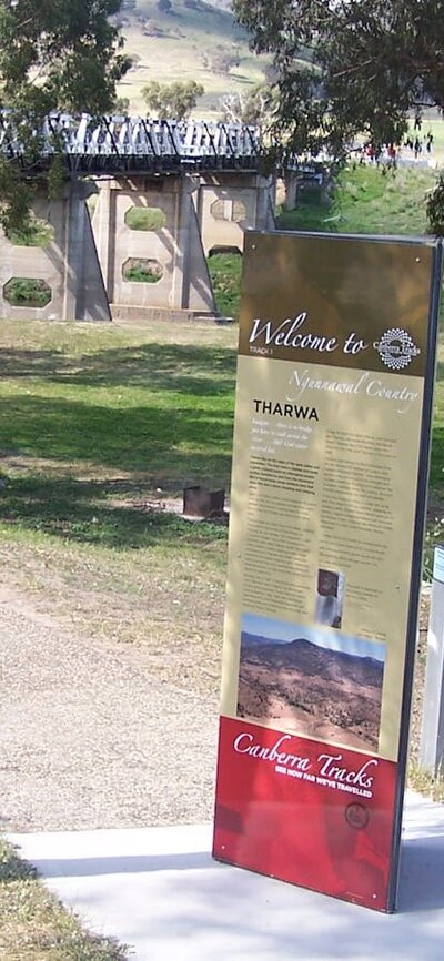 Tall information panel with park and bridge in background