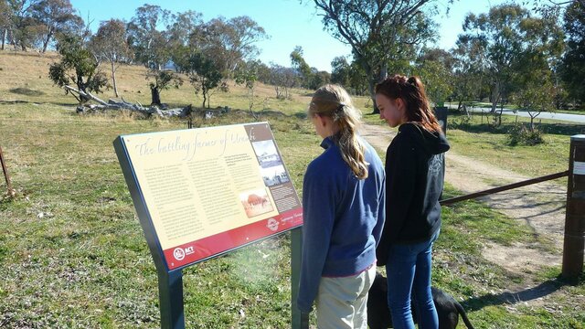 Urambi homestead was home to Gerry Sheehan, a colourful character. Two girls with dog at a sign board in open woodland