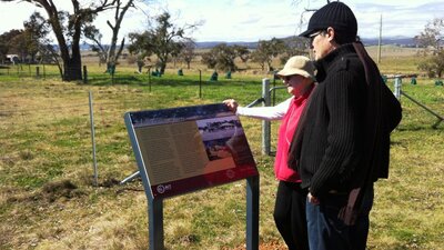 A couple viewing an information panel in farmland