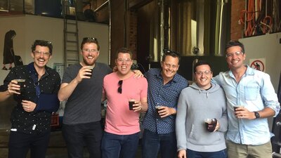 Happy men with beers on a brewery tour