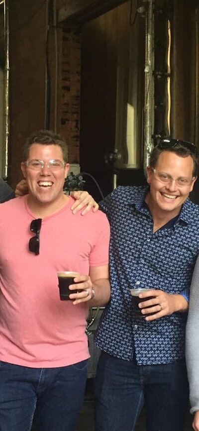 Happy men with beers on a brewery tour