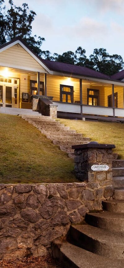 Couple standing on steps in front of caves house