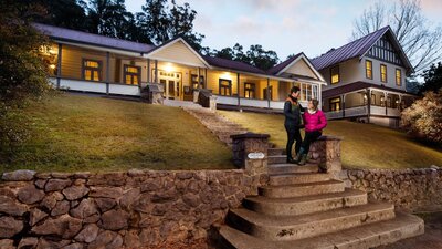 Couple standing on steps in front of caves house