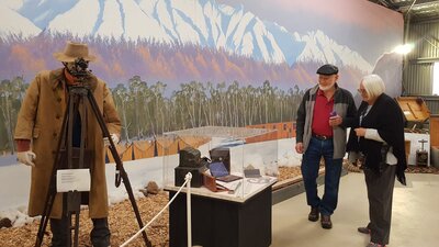 man and woman in front of mountain mural