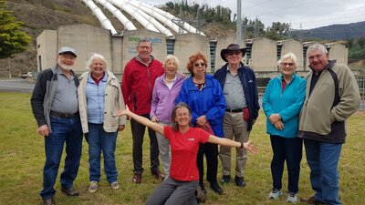 nine people in front of hydro electric power station