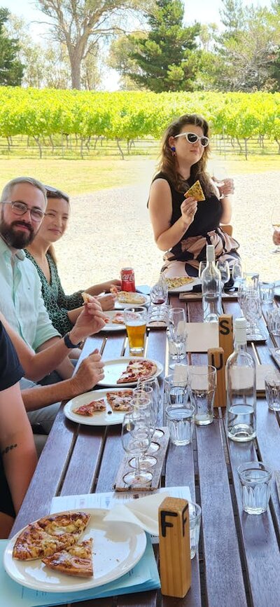 Group of friends posing for photo at Four Winds Vineyard on a Merry Heart CBR Great Tour