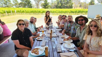 Group of friends posing for photo at Four Winds Vineyard on a Merry Heart CBR Great Tour