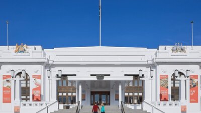 Two people walk up the steps of Old Parliament House