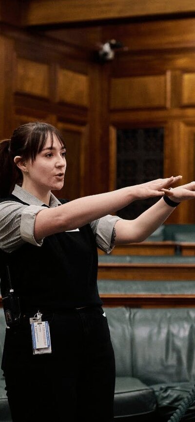 MoAD Experience Officer shows the tour group the House of Representatives chambers