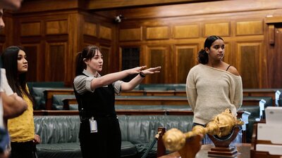 MoAD Experience Officer shows the tour group the House of Representatives chambers