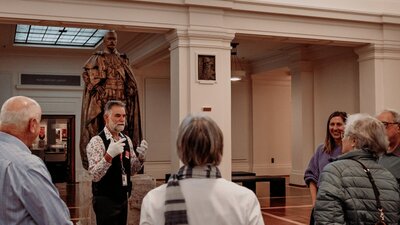 MoAD Experience Officer with a group of people gathered in King's Hall