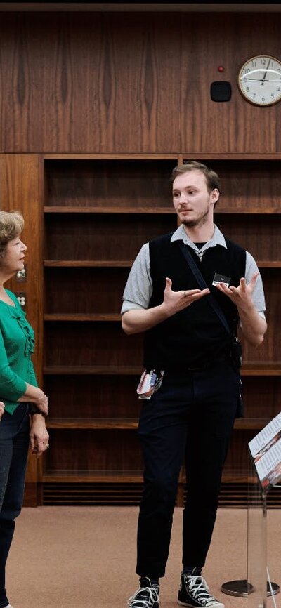 A MoAD Museum Experience Officer speaks to a group of people gathered in the Prime Minister's office