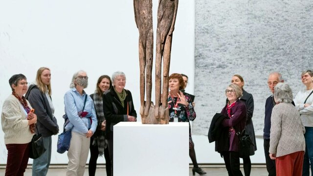 Tour in the gallery People gathered around a work of art